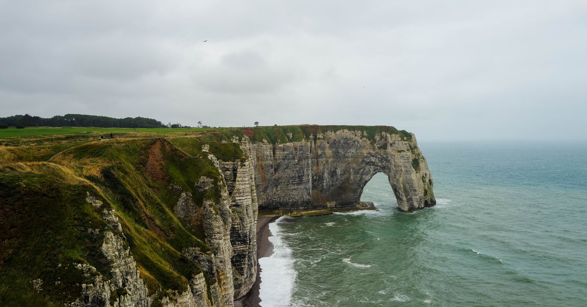 Stunning view of the iconic Etretat cliffs in Normandy, France with rough sea below.